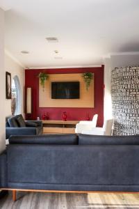 - un salon avec un canapé bleu et un mur rouge dans l'établissement Hotel San Telmo, à Aparecida