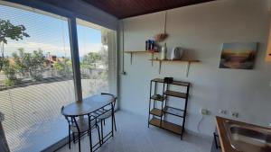 a kitchen with a table and chairs and a window at Apartma Niko in Piran