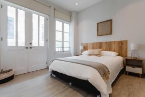 a bedroom with a large bed with a wooden headboard at Casa Love by Wynwood House in Panama City