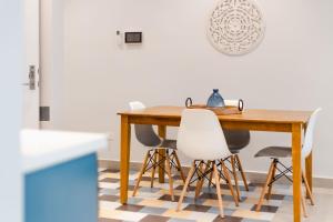 a dining room with a wooden table and white chairs at Casa Love by Wynwood House in Panama City