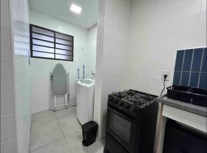 a small kitchen with a stove and a sink at Kitnet no Centro de Campinas in Campinas +2 photos