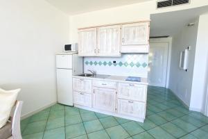 a kitchen with white cabinets and a white refrigerator at Ancora Resort in Acciaroli