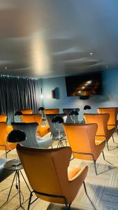 a room with orange chairs and tables and a blue wall at Cozy apartment with terrace, SJ Cosmopolitan Tower #402 in San José