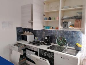 a kitchen with white cabinets and a stove top oven at Sun House in Montesilvano