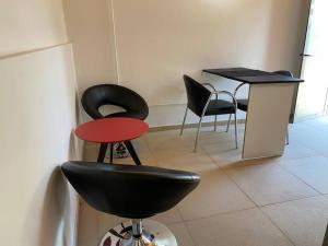 a room with black chairs and a table and a stool at Departamento 2 Pellegrini in Posadas