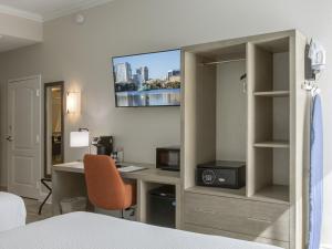 a hotel room with a desk and a bed and a computer at Galleria Palms Orlando - Free Theme Park Shuttles in Orlando