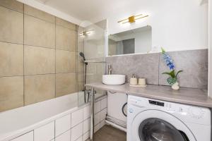 a laundry room with a washing machine and a sink at Duplex 6 Personnes Hyper Centre in Dieppe