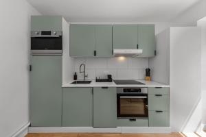 a white kitchen with white cabinets and appliances at Duplex 6 Personnes Hyper Centre in Dieppe