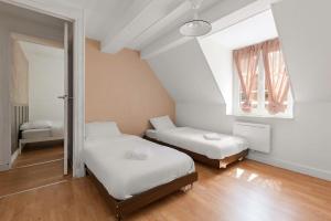 a bedroom with two beds and a window at Duplex 6 Personnes Hyper Centre in Dieppe