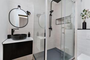 a bathroom with a shower with a sink and a mirror at Duplex 6 Personnes Hyper Centre in Dieppe +13 photos