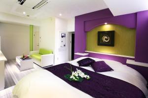purpurowa sypialnia z dużym łóżkiem z kwiatami w obiekcie Hotel L'eclair (Adult Only) w mieście Fukuyama
