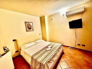 a bedroom with a large bed and a television at Lo scorcio del Borgo in Atrani
