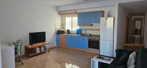 a kitchen with blue cabinets and a white refrigerator at Ático carrizal in Carrizal