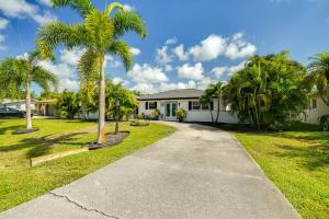 une maison avec des palmiers devant elle dans l'établissement Fort Myers Bungalow - 12 Miles to the Beach!, à Fort Myers