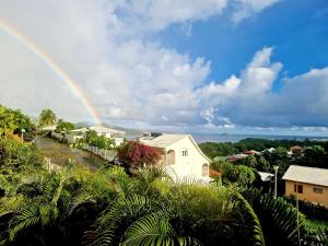a rainbow in the sky over a town with houses at Heaven-peace SWEETY in La Trinité