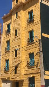 ein gelbes Gebäude mit Balkon an der Seite in der Unterkunft La maison du lac in Alger