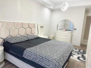 a bedroom with a bed and a dresser and a mirror at Midyat Merkezde Lüks Daire in Midyat