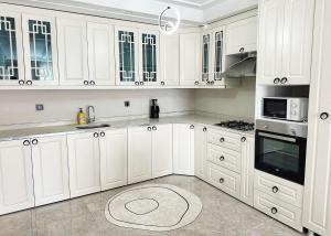 a white kitchen with white cabinets and appliances at Midyat Merkezde Lüks Daire in Midyat