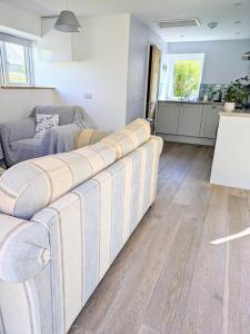 a living room with a couch and a kitchen at Sterennyk in Helston +13 photos
