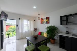 a kitchen and living room with a table and chairs at Apartamentos La Casona in Fortuna
