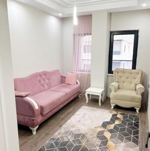 sala de estar con sofá rosa y silla en Midyat Merkezde Lüks Daire en Midyat
