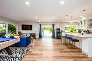 una cucina aperta con sgabelli blu e un bancone di Resort Style Living with Pool, Arcade, Near Disney a Fullerton