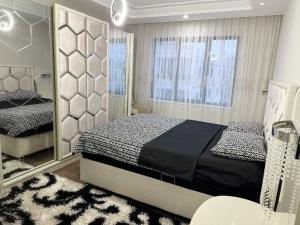 a bedroom with a large bed and a mirror at Midyat Merkezde Lüks Daire in Midyat
