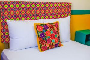 un lit avec une tête de lit colorée et un oreiller dans l'établissement Casa Paraiso, à Santa Cruz Huatulco