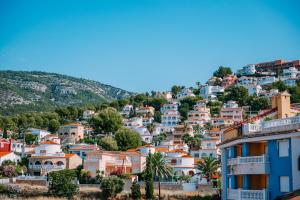 una città su una collina con case e palme di Ático Dúplex con piscina Marcolina ad Alcossebre