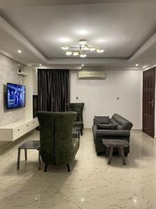 a living room with two chairs and a couch at SANDS HOMES IKOYI in Lagos