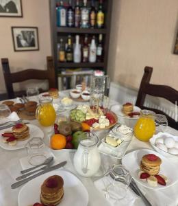 a table topped with plates of food and fruit at Deluxe Hotel in Berat