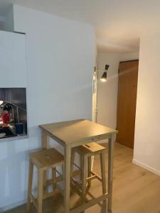 a wooden table and two stools in a room at Studio hypercentre résidence standing in Belfort