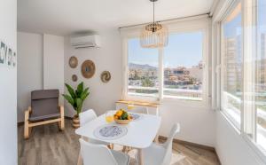 a white dining room with a white table and chairs and windows at Estrella de Mar in Torrox Costa +16 photos