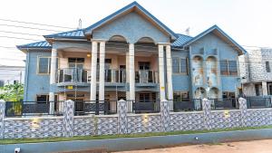 uma casa azul com uma cerca em frente em Digi Six-Bedroom Accra Luxury Home at East Legon and Close to Accra Airport em East Legon
