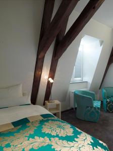 a bedroom with a bed and a blue chair at Schlosshotel Bergzaberner Hof in Bad Bergzabern