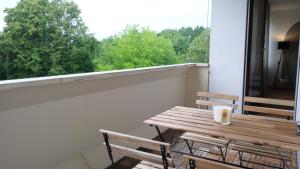 a wooden table and chairs on a balcony with a window at CASA LUXE - 120qm - Zentral - Familienfreundlich - Parkplatz - 5km zum Legoland in Günzburg