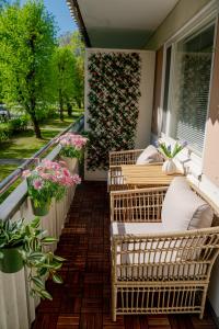un balcón con sillas de mimbre y flores en Pietarsaaren Helmi, en Jakobstad
