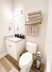 a white bathroom with a toilet and a sink at Cottage Marhome North - 10 min from beach & historic downtown in Saint Augustine +30 photos