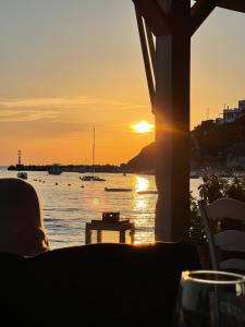 puesta de sol desde un restaurante con vistas al agua en Hayes suite syros, en Ermoupoli