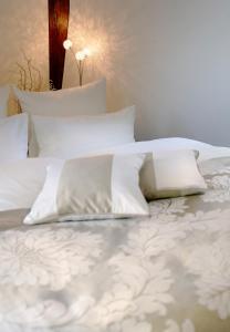 a white bed with white sheets and pillows at Schlosshotel Bergzaberner Hof in Bad Bergzabern