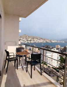 a balcony with a table and chairs and the ocean at ODORE DI MARE APARTMENTs in Sarandë