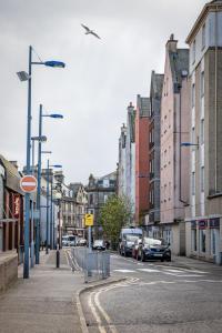 Una calle de la ciudad con coches aparcados en la calle. en Ness Station, en Inverness