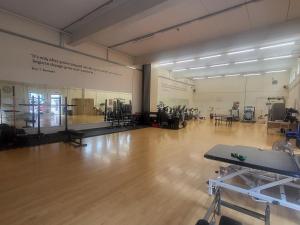 a large room with a wooden floor and a gym at Harcombe House Bungalow 7 in Newton Abbot