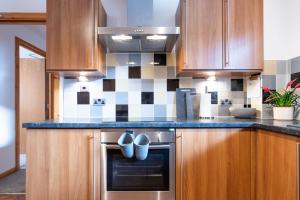 una cocina con armarios de madera y encimeras azules en Ness Station, en Inverness