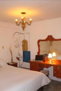 - une chambre avec un lit et un bureau avec un ordinateur portable dans l'établissement Casa om, à San Cristóbal de Las Casas
