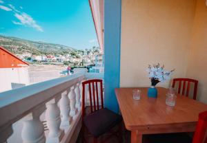 un tavolo con un vaso di fiori su un balcone di Ático Dúplex con piscina Marcolina ad Alcossebre