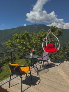 2 sillas y una mesa en una terraza con vistas en The overlook cottage, en Batumi