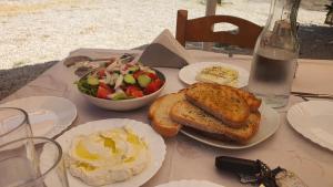 卢科沃Hotel Taverna Prifti的餐桌,盘子和一碗沙拉