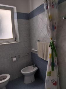 Un baño con inodoro y cortina de ducha. en Appartamento vacanze Piombino, en Piombino