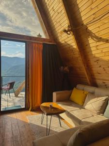 a living room with a couch and a large window at The overlook cottage in Batumi